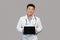 App for health care remote. Smiling korean chinese male therapist in white coat with stethoscope shows tablet