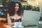 Appealing curly girl with laptop in street cafe outdoors