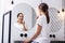 Appealing woman brushing teeth in front of circular mirror