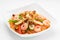 Appetising cellophane noodles with seafood in a white plate, close up on a white background