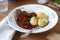 Appetizer from aubergines in a sauce of peppers and tomatoes, served with boiled potatoes. Rustic style, selective focus.