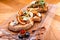 Appetizer bruschetta with cheese, honey, walnut and dry orange slices on wooden table. Close-up.