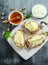 Appetizer bruschetta with pear, honey, walnut and cottage cheese on white board.