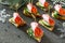 Appetizer canape on crispy bread with cucumber, carrots and sausage. Beautiful Christmas and New Year`s food background.
