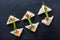 Appetizer canape with red caviar and cream cheese on stone slate background close up.