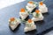 Appetizer canape with red caviar and cream cheese on stone slate background close up.