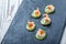 Appetizer canape with red caviar, shrimp and cream cheese on stone slate background close up.