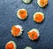 Appetizer canape with salmon, cucumber and cream cheese on stone slate background close up.