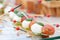 Appetizer, Caprese. Cherry tomatoes,mozzarella and Basil on skewers. . Pesto sauce. Tasty buffet table. Summer party