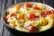 Appetizer Farfalle pasta salad with ripe avocado, onion and tomato closeup in a bowl. horizontal