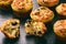 Appetizer - muffins with chicken, cheese and olives on black background.
