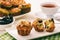 Appetizer - muffins with chicken, cheese and olives on white wooden background.