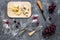 Appetizer parmesan cheese, cheese with blue mould and red grape on grey stone table background top view