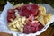 Appetizer plate: various cheeses, salami and ham on the table