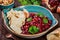 Appetizer with red bean, walnut, butter, coriander, parsley, chips on plate on wooden background. Healthy food.