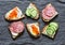 Appetizer sandwiches with red caviar, egg, sausage, cucumber and cream cheese on grey background