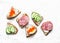 Appetizer sandwiches with red caviar, egg, sausage, cucumber and cream cheese on white background