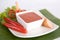 Appetizer sliced sausage on white dish served with chili sauce