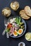 Appetizer table - plate of canned tuna, green beans, mozzarella cheese, tomatoes, boiled egg, olives, grilled bread and two glasse