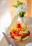 Appetizer on a wooden surface. Fish a salmon with slices of a lemon or lime and tomato on a plate.