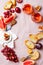 Appetizers, antipasti snacks and rose wine in glasses. Cheese and fruit platter over pink linen tablecloth