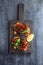 Appetizers with grilled aubergines, bell peppers and basil. Dark background
