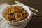 Appetizing asian japanese chinese cuisine with chicken and vegetables pepper with udon wok noodles in a white plate on a wooden