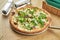 Appetizing baked pizza with wild mushrooms, parmesan and arugula with crispy crust on a wooden background. Restaurant table