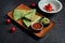 Appetizing baked quesadilla with minced chicken of cheese in green tortilla on a ceramic plate on a black background. Modern