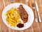 Appetizing beef entrecote with baked potatoes served at plate
