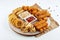 Appetizing beer snack - a set of deep-fried snacks, mozzarella, onion rings, fish sticks, potato croquettes with sauce and on a