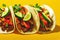 Appetizing bright tacos mexican with lime folded on yellow background