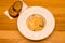 Appetizing carbonara pasta with egg yolk on a white plate in a restaurant, two pieces of bread lie on wooden table