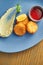 Appetizing chicken croquettes breaded with red sauce and mashed potatoes on a blue plate with spicy red sauce. Wood background