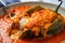 Appetizing close-up of Chiles Rellenos stuffed with shredded chicken and topped with a zesty tomato sauce