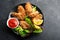 Appetizing crispy chicken wings breaded with bread crumbs with lettuce, sauce, lemon, microgreens in a plate on the