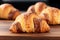 Appetizing croissants close up on wooden bakery shelf