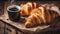 Appetizing French croissant on a wooden table, mug of coffee with hot steam