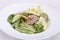 Appetizing fresh salad with pumpkin seeds, greens and boiled baby veal.