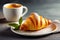 Appetizing freshly baked croissant with flaky buttery texture on white plate with cup of hot coffee. Copy space for text