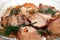 Appetizing fried pork meat pieces with carrot and dill in transparent dishware closeup