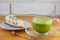 Appetizing green cheesecake with matcha tea on wooden background