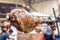 Appetizing grilled pork on the spit. Roasted leg of porkon traditional barbecue. Prepared of a ram pig baked pork meat Street food