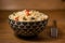 Appetizing healthy rice with vegetables in a bowl on a wooden background.