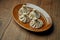 Appetizing homemade khinkali with different fillings minced meat, cheese, vegetables or spinach in a brown plate on a wooden