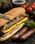 Appetizing hot dog. Bread with sausages, cheese and salad. Hearty burger with sesame seeds, nutritious snack. Close-up