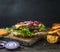 Appetizing juicy home burger with beef, salad, pickled cucumbers, cheese and onion,potato ,wedges, bun with sesame, on vintage c