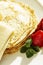 Appetizing pancakes with strawberries and mint leaves on a plate. Traditional dish for the carnival holiday. Close-up. Vertical