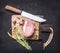 Appetizing piece of raw pork steak on vintage cutting board with herbs and spices for meat a knife on wooden rustic backgroun