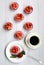 Appetizing pink cupcakes with strawberries and cream on a white plate and a light wooden background